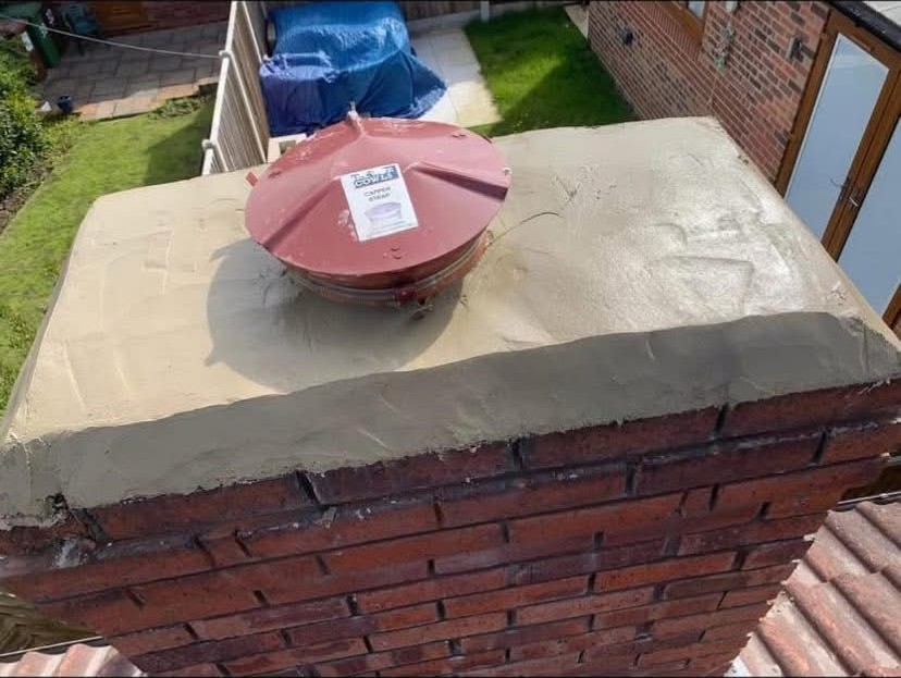 New sand and cement flaunching with capped chimney cowl fitted to a red brick stack