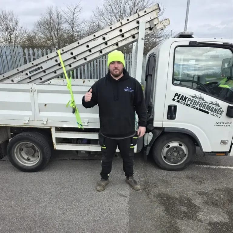Davin Price, owner of Peak Performance Roofing, stood beside the company tipper truck with roof ladders loaded