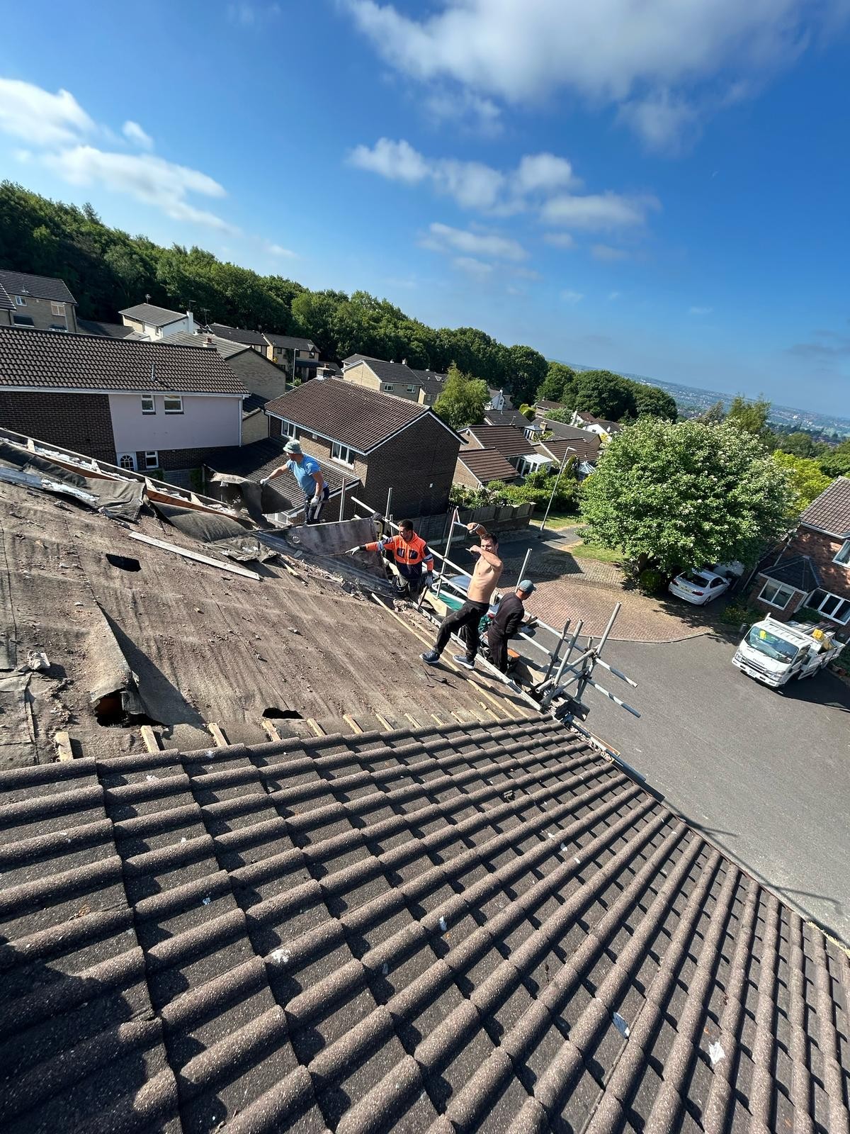 Aged tiles and failing felt on a roof before replacement