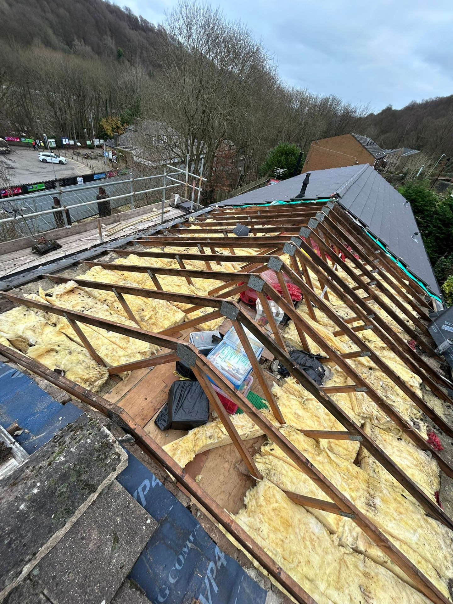 Roof timbers and loft insulation exposed after stripping the old covering for a re-roof