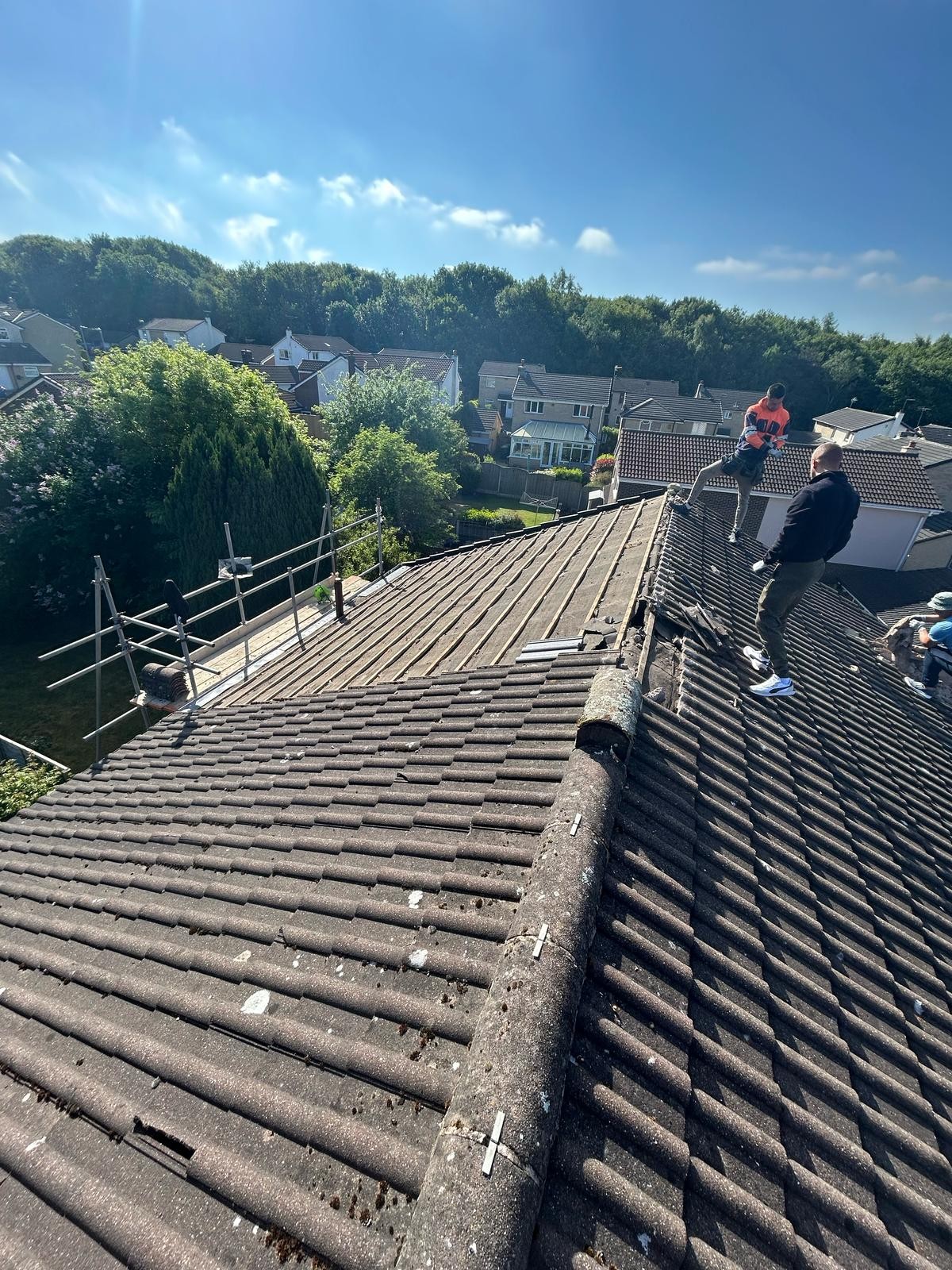 Roofer on a stripped pitched roof preparing the structure for new tiles