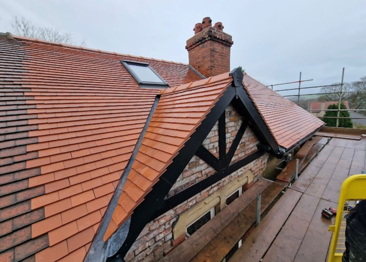 Red tiled hipped roof with new gable timbers finished by Peak Performance Roofing