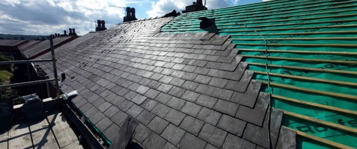 Stone slates being re-laid over new green breathable membrane and battens