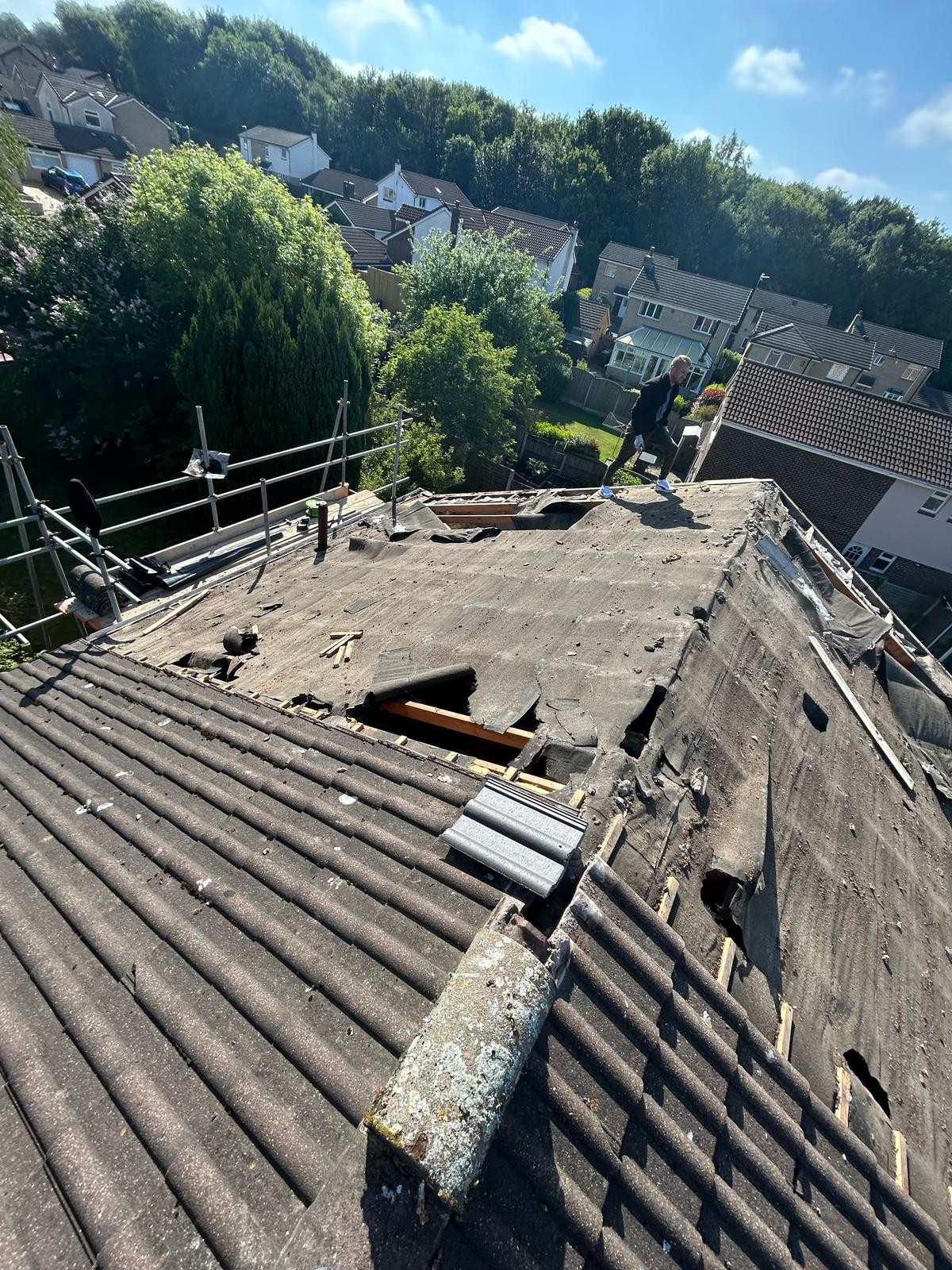 Worn concrete tiles and failed felt on a roof due for full replacement